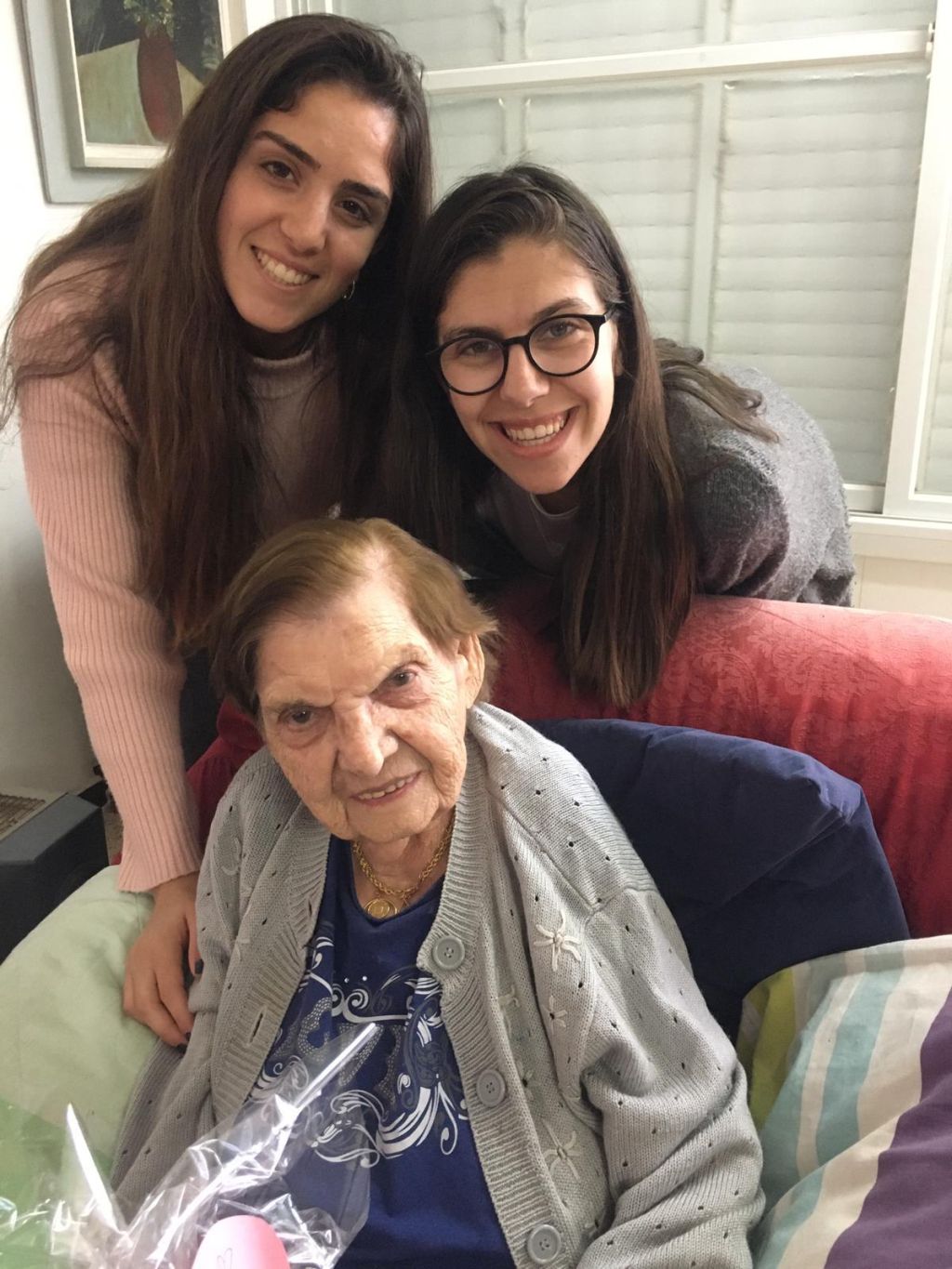 Nurit, de pie, a la izquierda, con una compañera y una señora mayor a quien visitaron (antes de la crisis actual), para hacerle compañía