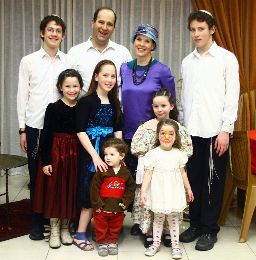 Rajel Fraenkel y su esposo, con sus siete hijos, siempre incluyendo a Naftali en el presente