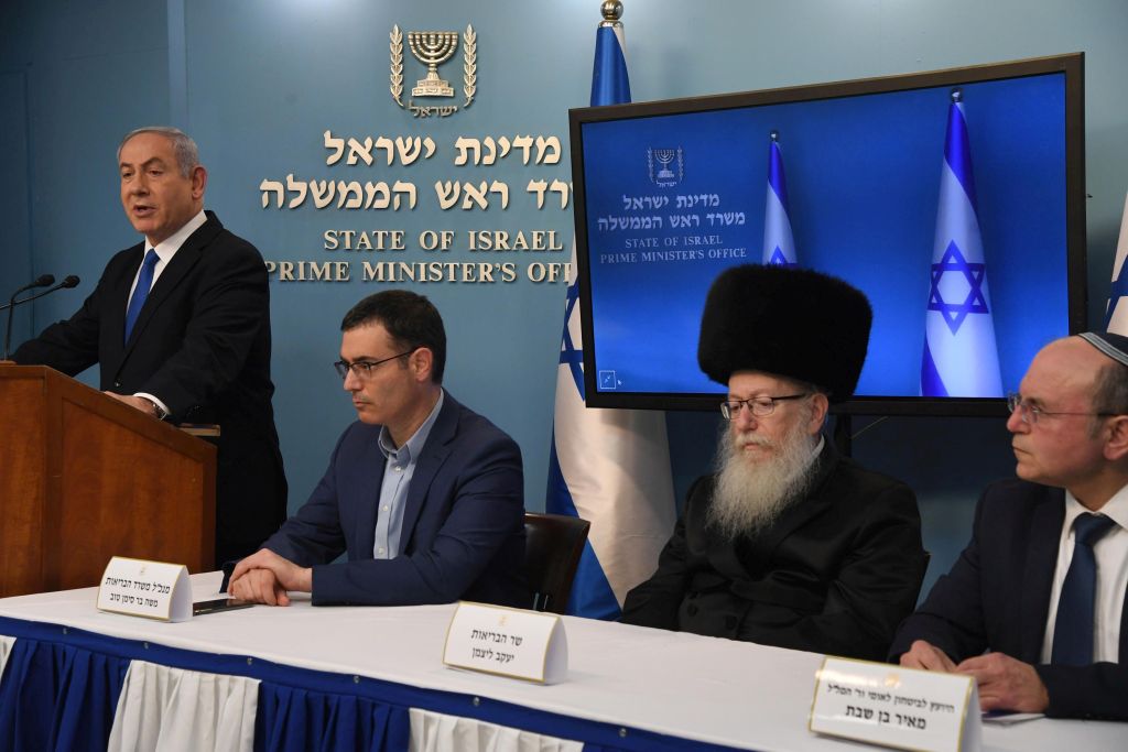El Primer Ministro Biniamin Netanyahu dirigiéndose a la ciudadanía. Sentados, el Director General del MSP Moshe Bar-Siman Tov, el Ministro de Salud Pública Yaakov Litzman y el Director del Consejo de Seguridad Nacional Meir Ben-Bassat (Foto: GPO)