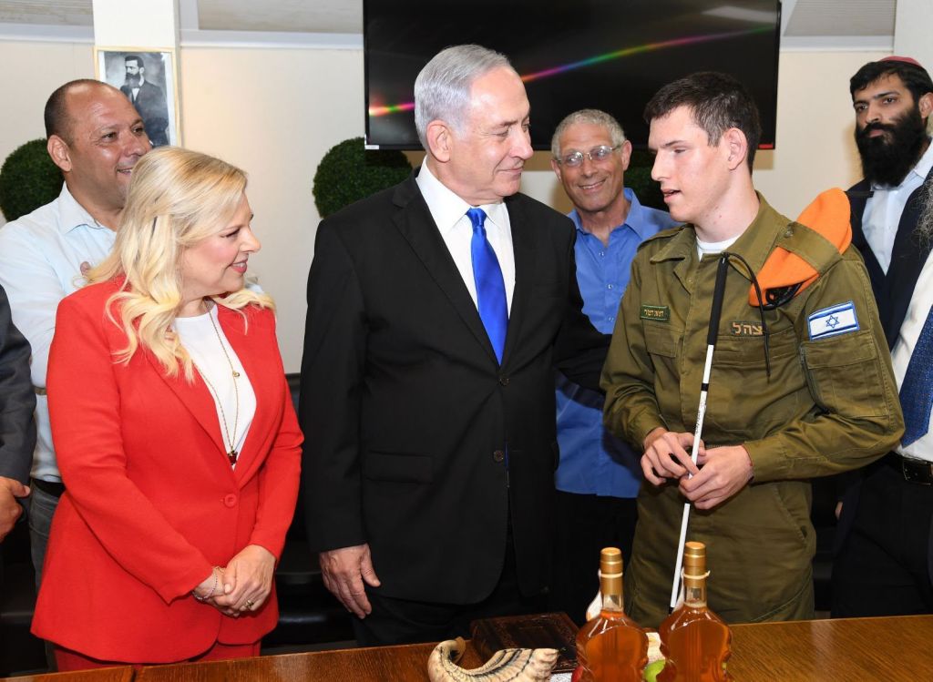 Los Netanyahu con un soldado ciego, en el brindis en el Ministerio de Defensa