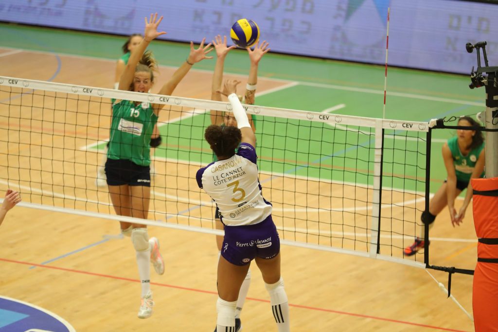 Del otro lado de la red, 3 jugadoras de Hapoel Kfar Saba, frente a una jugada de la del equipo contrario, junto a la red