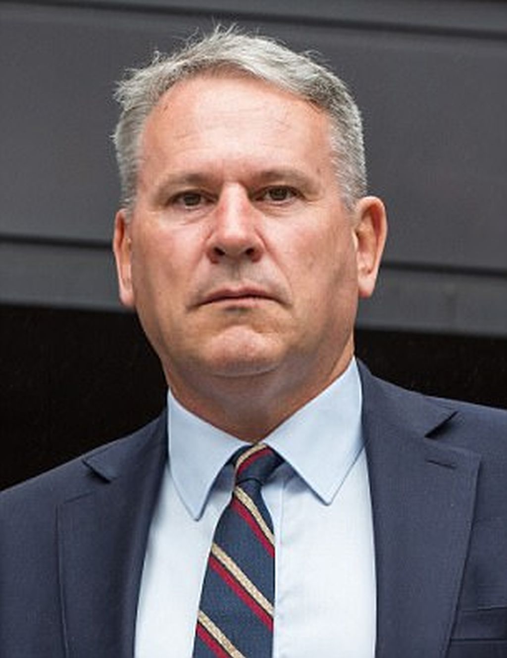 Richard Kemp, de traje, serio, mirando a la cámara