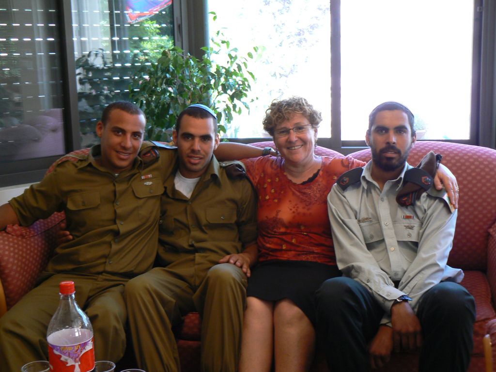 Miriam Peretz con tres de sus hijos, entre ellos uno de los caídos Miriam Peretz sentada, rodeada de 3 de sus hijos