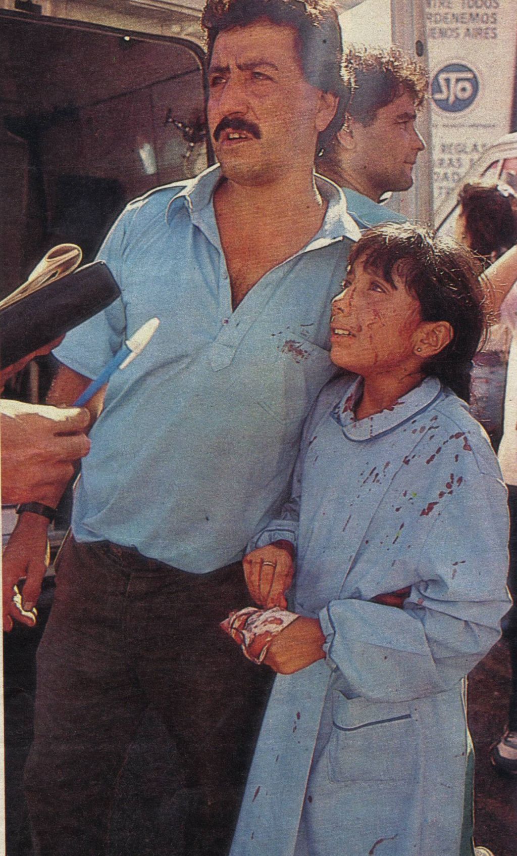 Una niña con la túnica ensangrentada, junto a un hombre, llorando. Atentado Embajada de Israel en Buenos Aires.