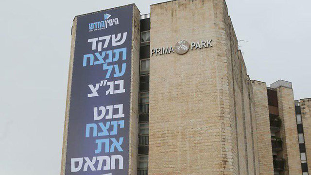 Un cartel largo, en hebreo, cuelga de una pared
