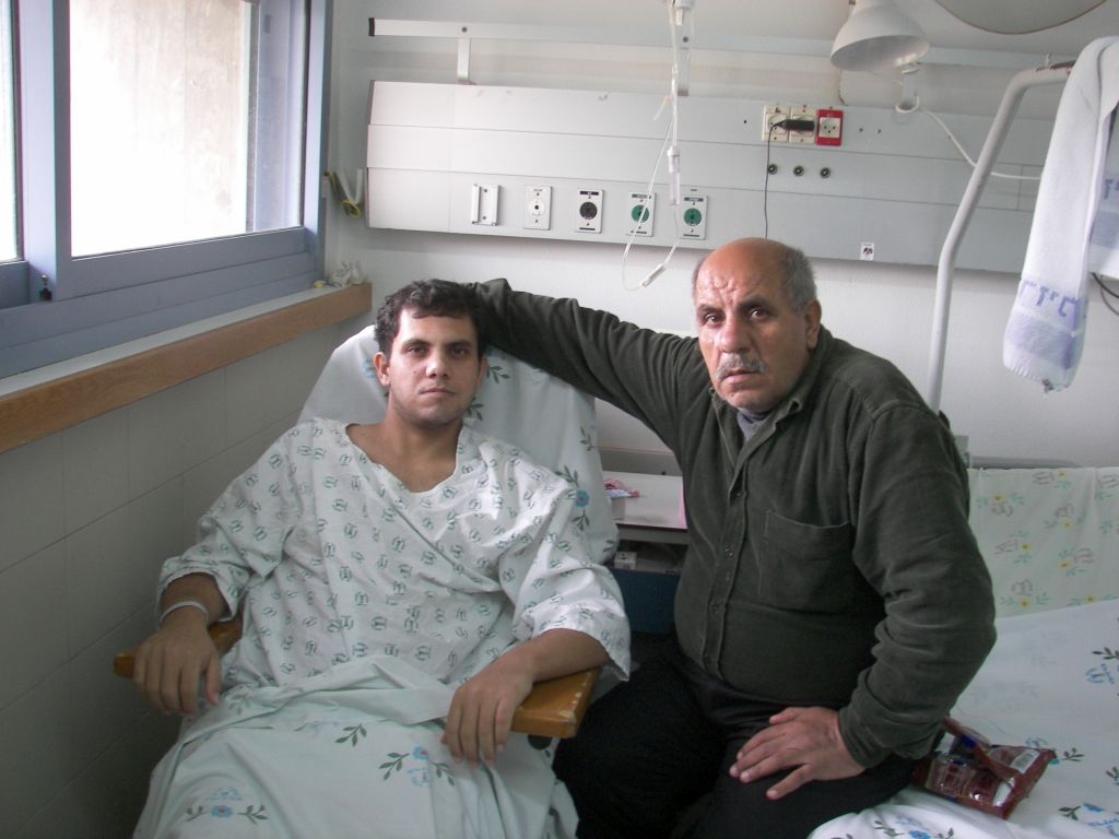 Heridos palestinos de Gaza, en hospital israelí Un joven herido, hospitalizado, junto a su padre. Palestinos de Gaza