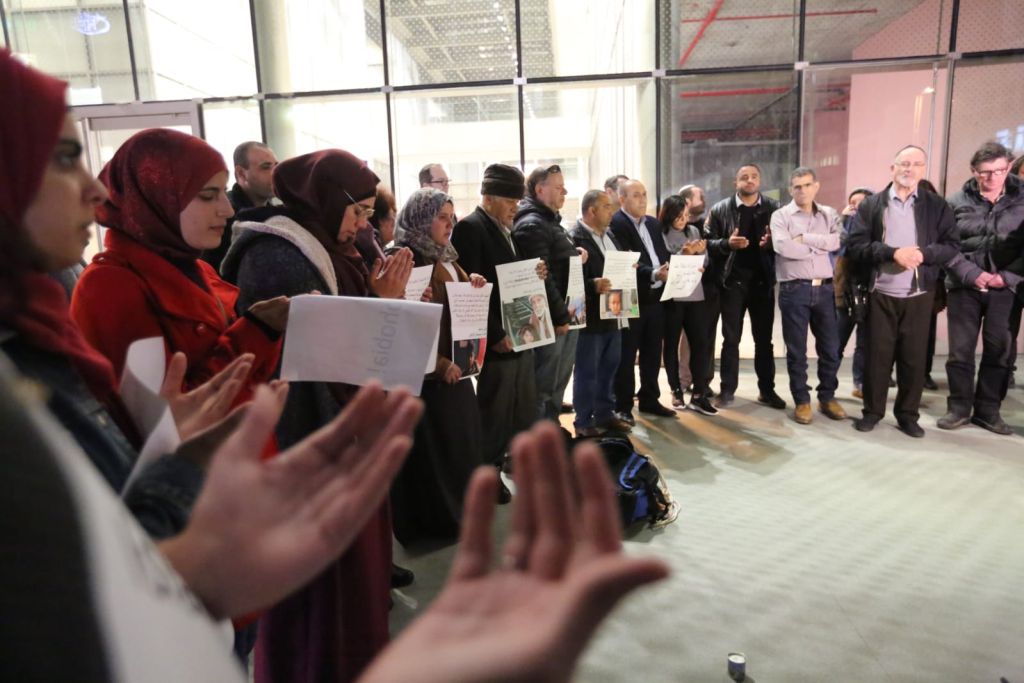 Un grupo de gente, parados en línea semicircular, los musulmanes con las manos al frente, orando