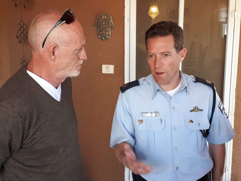 Shlomo Moskowicz, dueño de la casa en Sderot impactada por un proyectil lanzado desde Gaza, con el portavoz internacional de la Policía israelí Micky Rosenfeld Un oficial de policía hablando con un civil. Israel.,