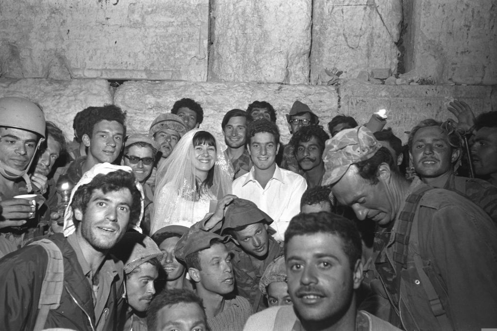 Una pareja rodeada de soldados que celebran, en matrionio judío en Muro de los Lamentos