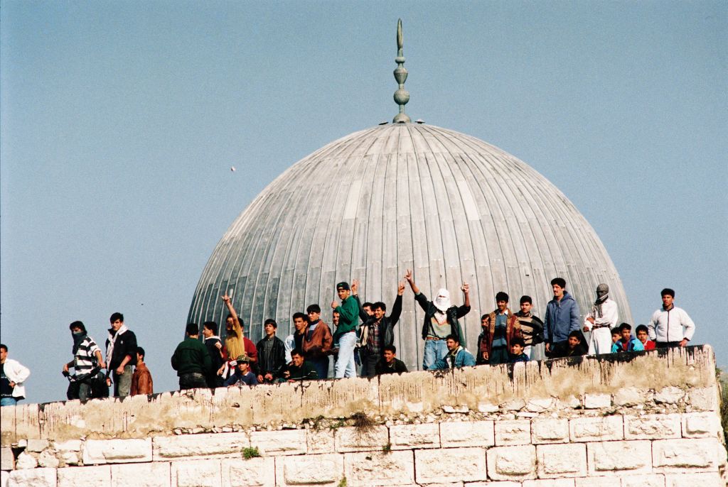 Palestinos tiran piedra desde el Monte del Templo/Haram el Sharif hacia los judíos orando abajo en la explanada del Muro de los Lamentos