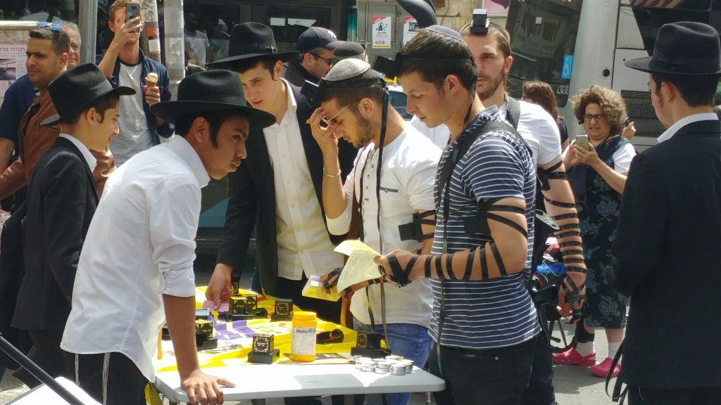 Jóvenes poniéndose Tfilin para la plegaria judía Jóvenes poniéndose Tfilin para la plegaria judía