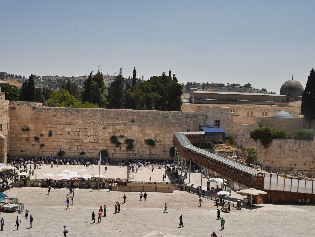 El Muro de los Lamentos, y atrás, arriba, el Monte del Templo. Se puede distinguir la cúpula de la mezquita de Al Aksa. La rampa a la derecha del muro es el acceso para los judíos al Monte.