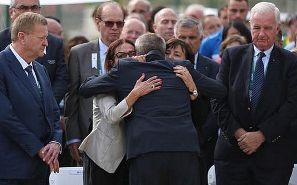en recuerdo de los atletas israelíes, en Río de Janeiro Thomas Bach, Presidente del Comité Olímpico Internacional, abraza a Ilana Romano y Ankie Shpitzer, viudas de dos de los atletas israelíes asesinados en las olimpíadas de Munich, al inaugurar el monumento en su memoria en la Villa OIímpica de Rio de Janeiero en el 2016. (Foto: AP Photo/Edgard Garrido, Pool)