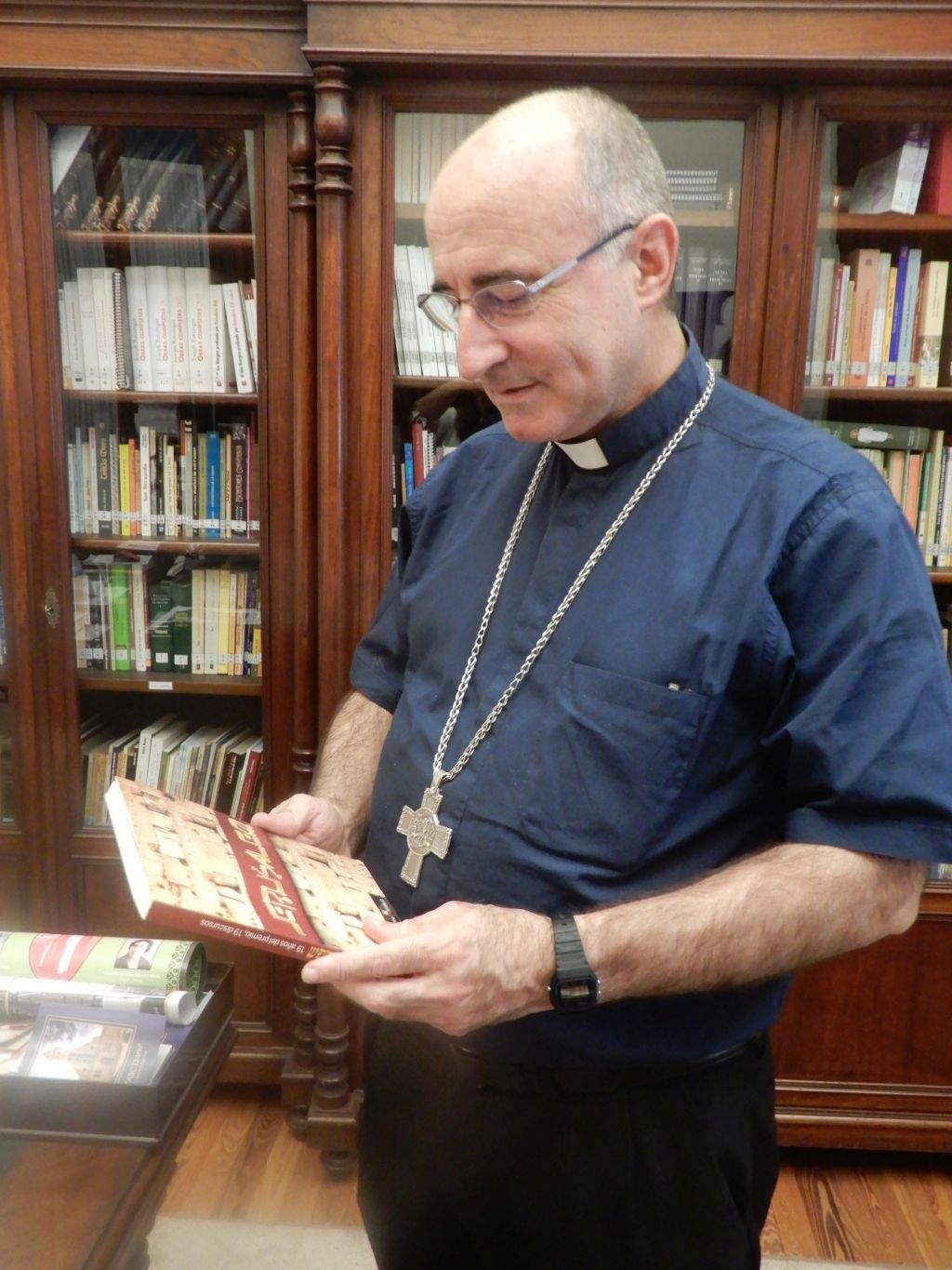 El Cardenal Sturla, en su oficina, con el libro que contiene los discursos de los Premios Jerusalem