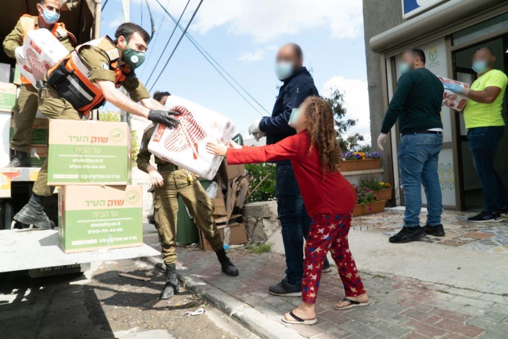 Soldados del Frente de Defensa Civil repartiendo productos básicos  a familias necesitadas en la población árabe israelí (Foto: Dover Tzahal)