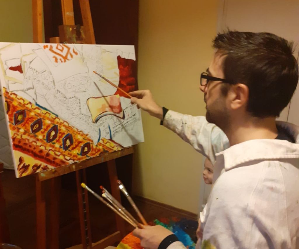 Pintando, mientras su hijito Matías observa y admira. No se lo pierdan, a la derecha, sonriente.