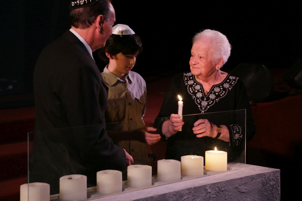 En un acto de Iom HaShoá en la Kehilá, el Sr. Kerekes enciende una vela recordatoria junto a la Sra. Clara Singer y uno de sus nietos, en recuerdo a las víctimas del nazismo