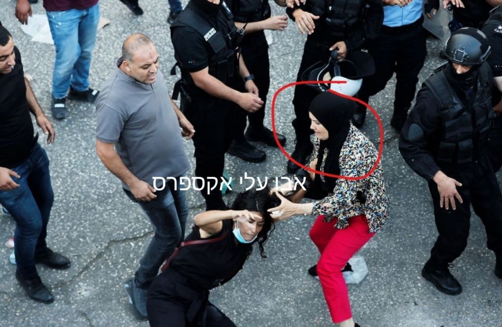 Una agente de seguridad palestina, de civil, chocando con una manifestante