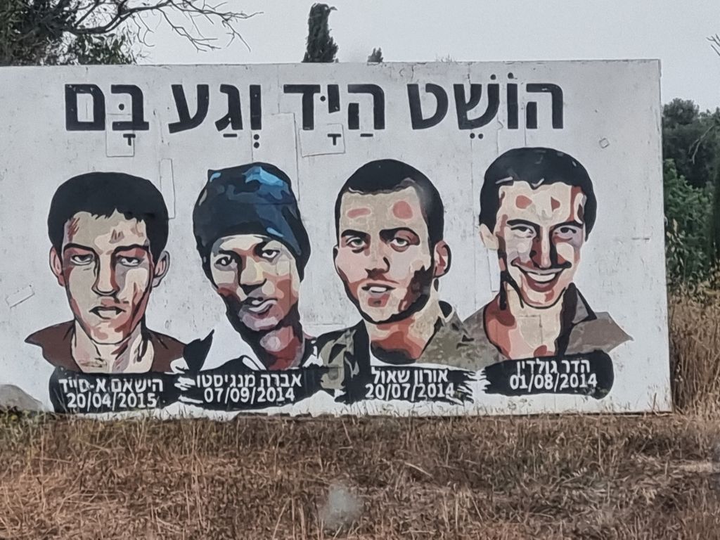 Un impactante cartel en el que fueron dibujados los rostros de los 4 israelíes prisioneros de Hamas, en una carretera del sur de Israel, a pocos kilómetros de Gaza