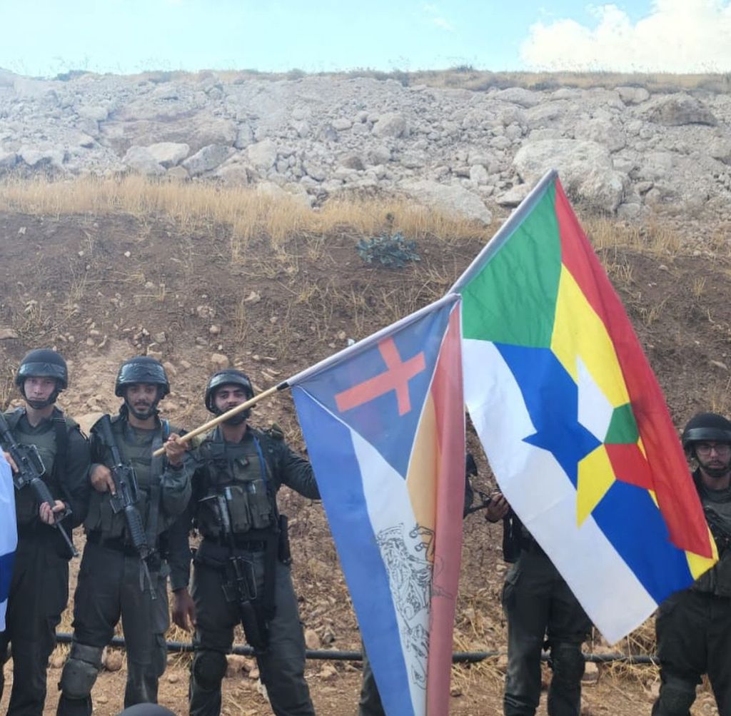 Efectivos cristianos israelíes con su bandera, junto a compañeros israelíes de la comunidad drusa con la suya, en el marco de un entrenamiento en la Guardia de Fronteras
