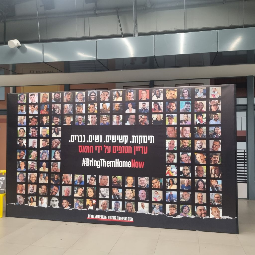 Un viejo cartel con los rostros de los secuestrados-antes de regreso de parte de ellos hace más de un año- en una estación de trenes en Tel Aviv