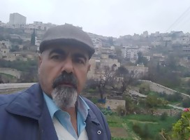 El palestino Rajji Sabatin, de fondo su aldea