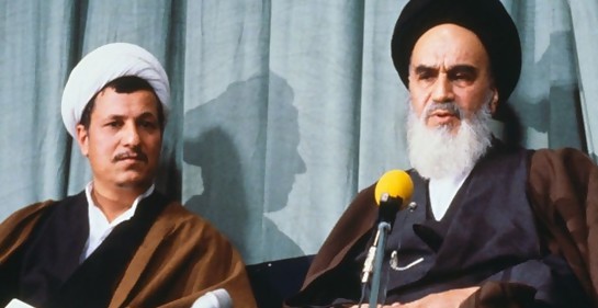 A la izquierda Rafsanjani, que fue presidente de Irán, sentado junto al líder de la revolucion islámica en Irán el Ayatollah Khomeini. Hay dos micrófonos.