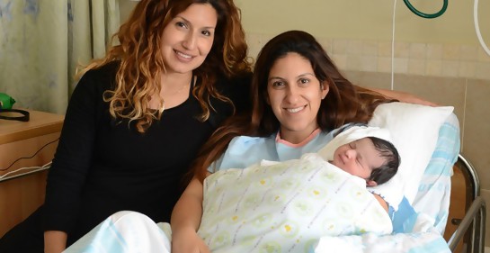 Las hermanas Moran y Shani Nahum en el hospital Rambam. Una de ellas tiene a su bebé en brazos mientras ella está  sentada en la cama, Su hermana está a su lado,