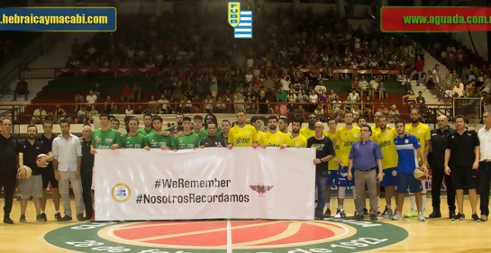 Aguada y Hebraica Macabi, jugadores y equipos técnicos, sostienen en el estadio de Aguada una pancarta blanca con la leyenda WeRemember y su traducción NosotrosRecordamos.Es la foto oficial en la que aparecen los escudos de los dos equipos y de la Federac