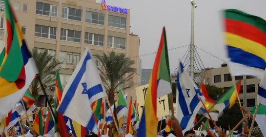 Manifestantes drusos israelíes enarbolan banderas de Israel y de la comunidad drusa, en la plaza Rabin en Tel Aviv