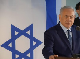 El premier israelí Netanyahu, junto a una bandera de Israel.