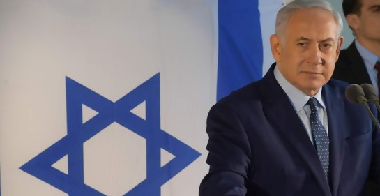 El premier israelí Netanyahu, junto a una bandera de Israel.