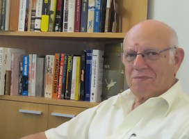 El Dr. Asculai en su oficina en el INSS , de fondo biblioteca con libros.