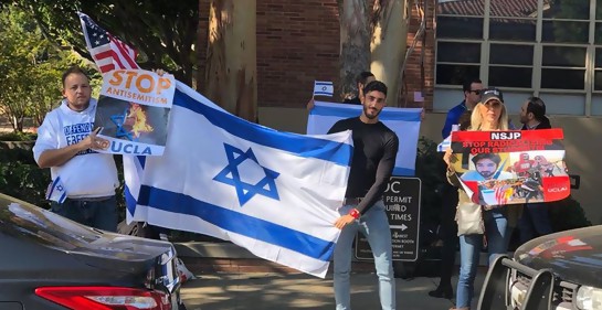 Un grupo de jóvenes, con carteles yuna bandera de Israel, en un campus universitario en EEUU. De negro, Ali Adi, árabe musulmán.