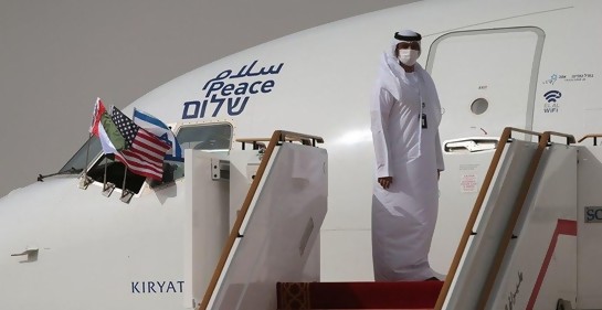 Funcionario emiratí, de galabía blanca, junto al avión de El Al, en la escalerilla