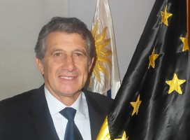 Fernando Morena, de traje, con la bandera de Peñarol. Atrás suyo, el pabellón nacional de Uruguay