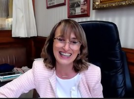 Carmen Asiaín, en su escritorio, sonriente, en la silla de su despacho