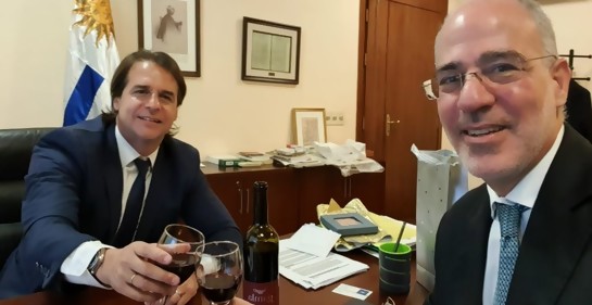 Magen y el Presidente brindando, de fondo la bandera uruguaya