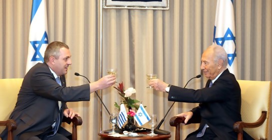 Greiver y Peres brindando. De fondo, la bandera de Israel.