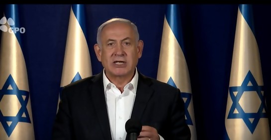 Netanyahu hablando, de fondo banderas de Israel