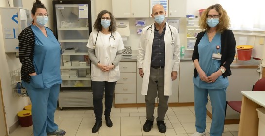 Cuatro miembros de un equipo médico, uniformados con ropa de hospital
