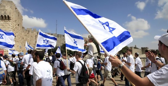 Jóvenes vestidos con remeras blancas, con banderas de Israel